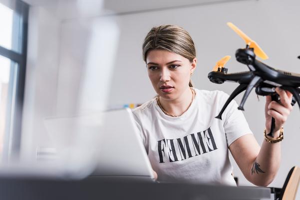 Una mujer tiene un drone en sus manos y lo testa