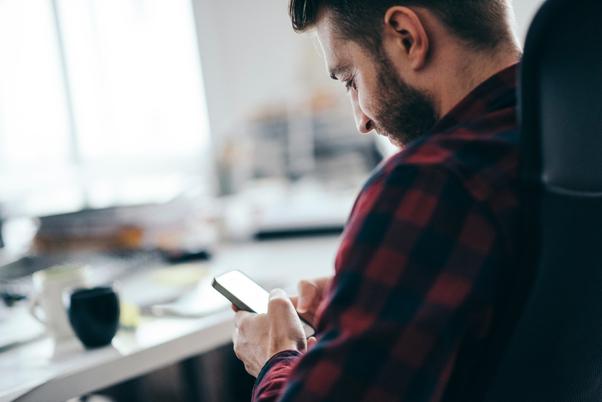 Un hombre ve la pantalla de su celular