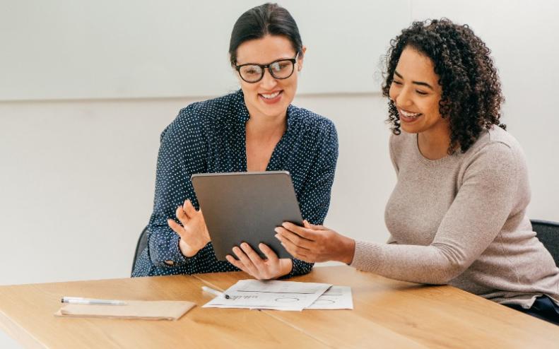 Dos mujeres leen un contrato en una tableta